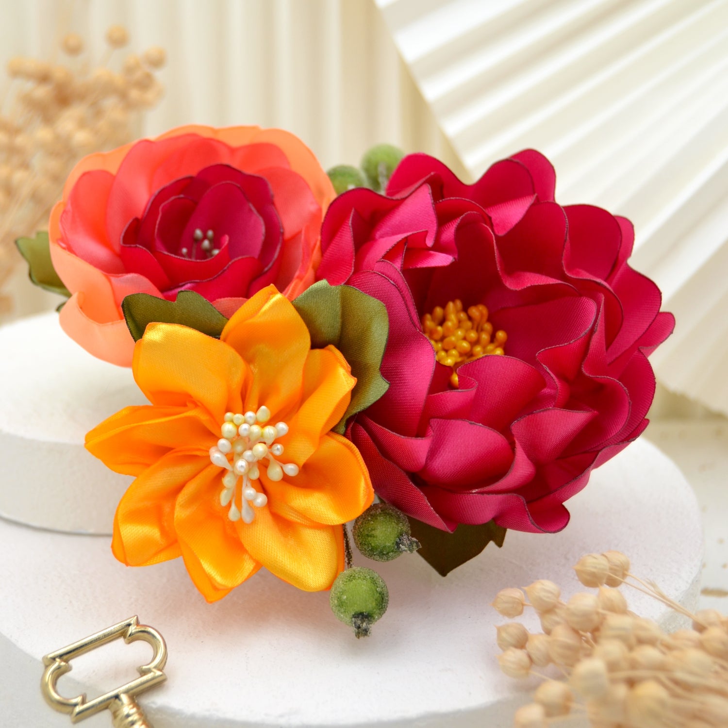 Einzigartiger Fascinator mit tropischem Flair – drei lebendige Blüten in Gelb, Pink und Koralle, umgeben von Blättern und Beeren.