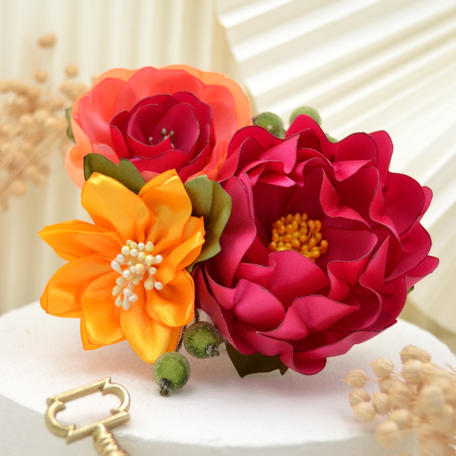 Exotischer Fascinator – Handgefertigte Blumen in Gelb, Pink und Koralle, umgeben von Blättern und grünen Beeren.