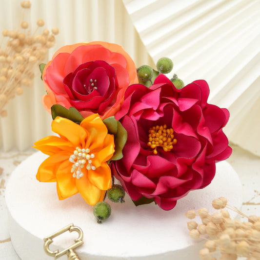 Handgefertigter Fascinator mit gelber Blüte, pinker Wildrose und pink-korallenfarbener Blume, verziert mit Blättern und Beeren.